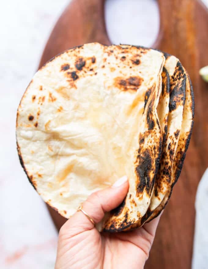 a hand holding charred tortillas close up