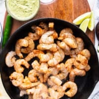 seasoned shrimp added to a skillet to cook