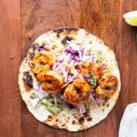 Layered charred tortillas now with sauce and slaw and some of the cooked shrimp