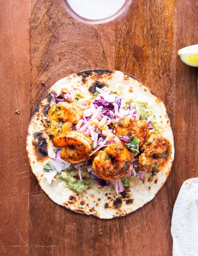 Layered charred tortillas now with sauce and slaw and some of the cooked shrimp