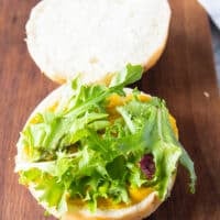 Assembling the tuna burger, a spread of sauce, some lettuce