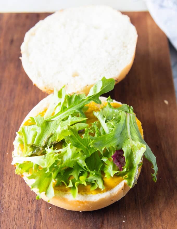 Assembling the tuna burger, a spread of sauce, some lettuce