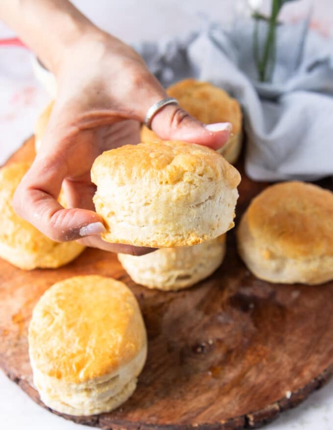A hand holding a fluffy air fryer biscuit close up