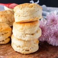 Stacks of air fryer biscuits on a wooden board show how tall and fluffy the biscuits are