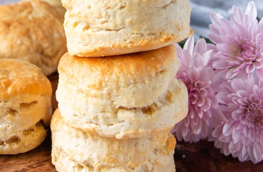 Stacks of air fryer biscuits on a wooden board show how tall and fluffy the biscuits are