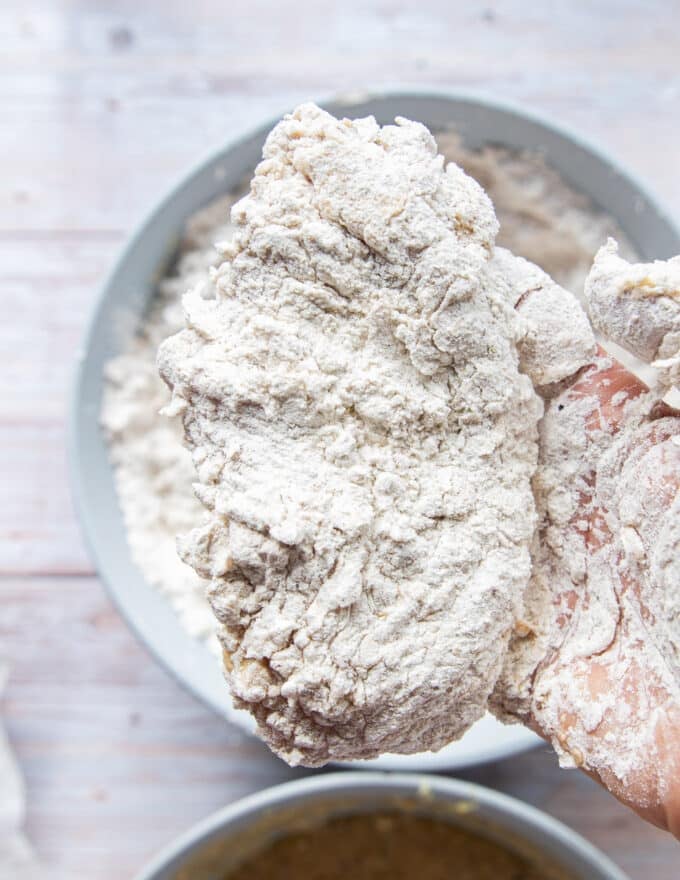 The final thick coating of flour is added to the chicken before frying