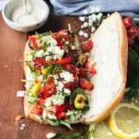 The fresh ingredients are added over the creamy sauce on the bread