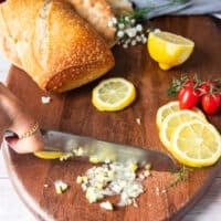 A hand slicing lemon slices into pieces for a secret ingredient to the sandwich by infusing maximum lemon flavor