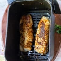 Perfect cooked air fryer cod in the air fryer basket.