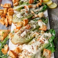 the grilled romaine plate is now topped with cheese, croutons, herbs and some chili flakes