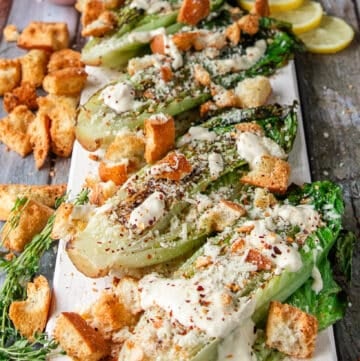 the grilled romaine plate is now topped with cheese, croutons, herbs and some chili flakes