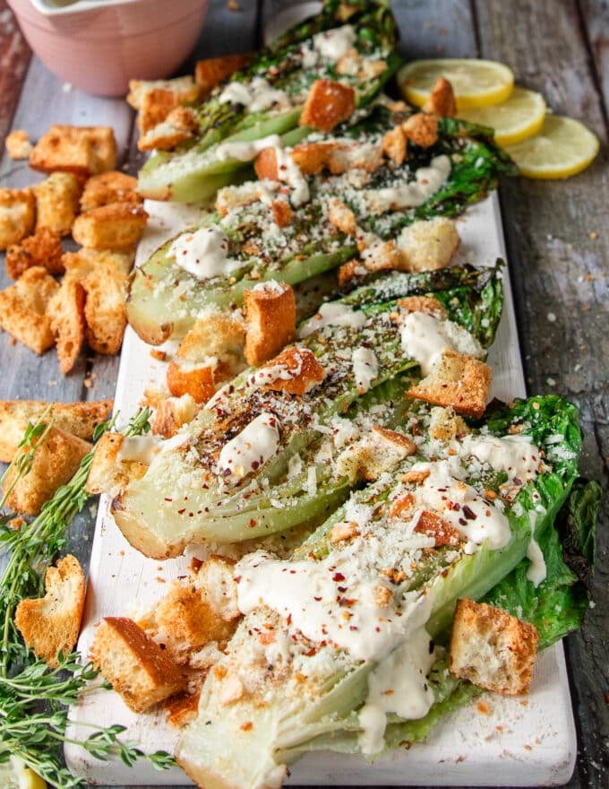 the grilled romaine plate is now topped with cheese, croutons, herbs and some chili flakes