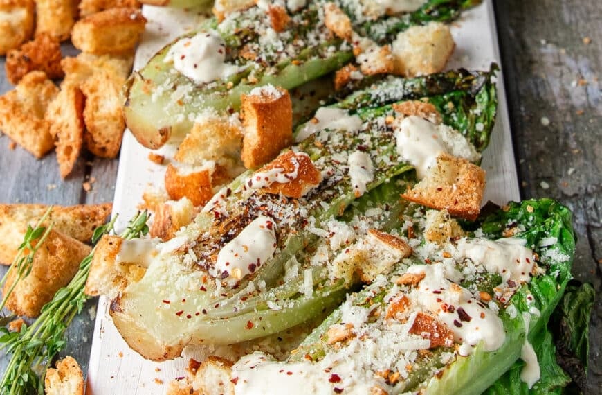 the grilled romaine plate is now topped with cheese, croutons, herbs and some chili flakes