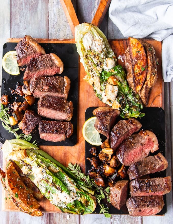 Plated and sliced picanha steak with potato wedges and grilled romaine lettuce 