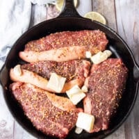 picanha steaks added to a hot cast iron in neutral oil