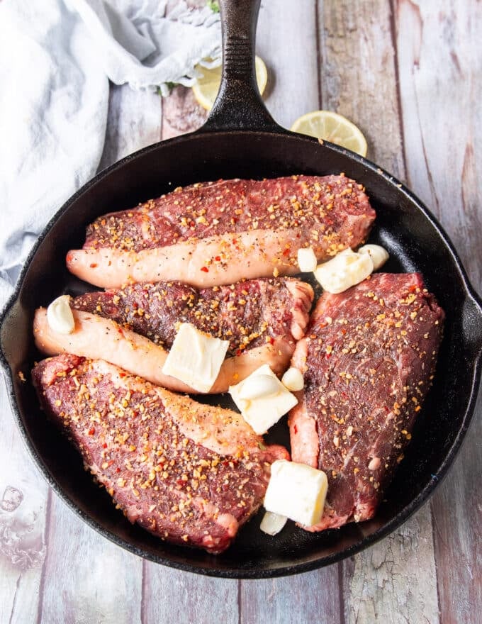 picanha steaks added to a hot cast iron in neutral oil 