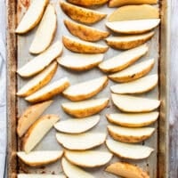 Potatoes washed and cut into wedges, laying on a baking sheet