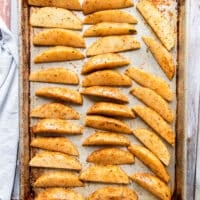 Seasoned potato wedges on a baking sheet in a single layer and ready to bake