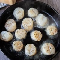 Scallops added to a hot pan for searing in butter
