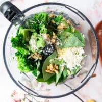 Broccoli pesto ingredients all added into a food processor bowl