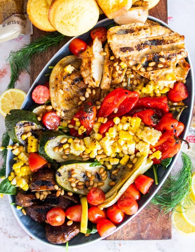 A platter of grilled chicken salad with grilled veggies and a simple lemon dressing
