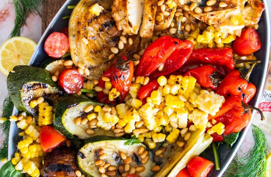 A platter of grilled chicken salad with grilled veggies and a simple lemon dressing
