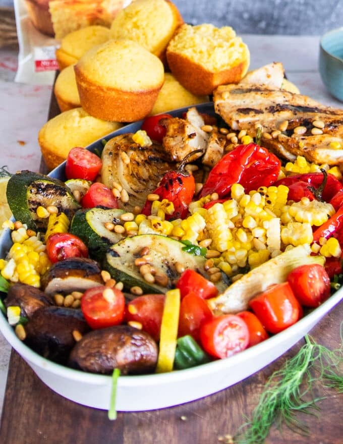 side view close up of a grilled chicken bowl with the grilled veggies and lemon dressing