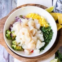 The diced scallops are added over the bowl of ceviche ingredients and ready to mix