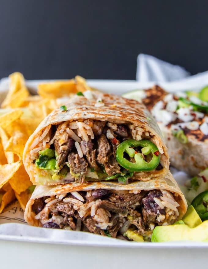 sliced burrito in half showing the filling close up and the consommé dip