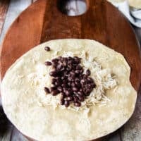 birria burrito fillings loaded, starting with rice and black beans