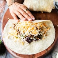 rolling the perfect burrito step by step beginning by folding one edge over half the filling