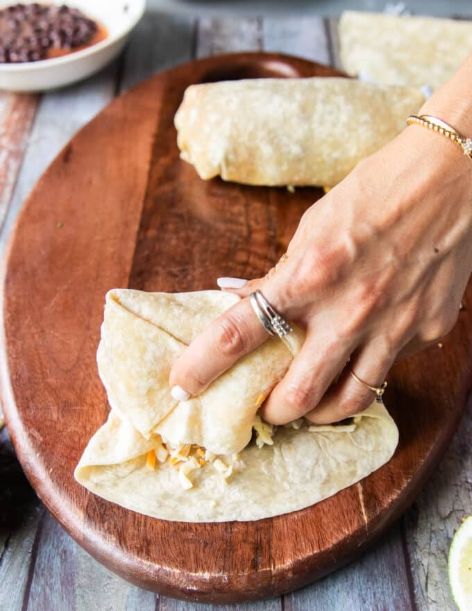 Continuing to roll the burrito, both sides and front are clumped together to enclose the filing fully 