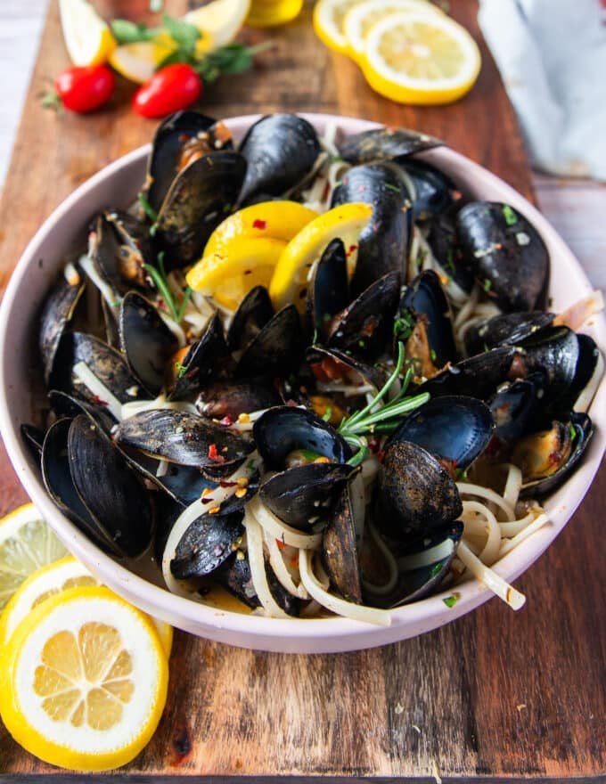 side view of mussel pasta with lemon slices and chilli flakes