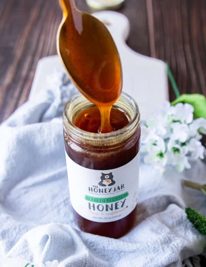 A jar of honey is the only ingredient here with a spoon showing the honey