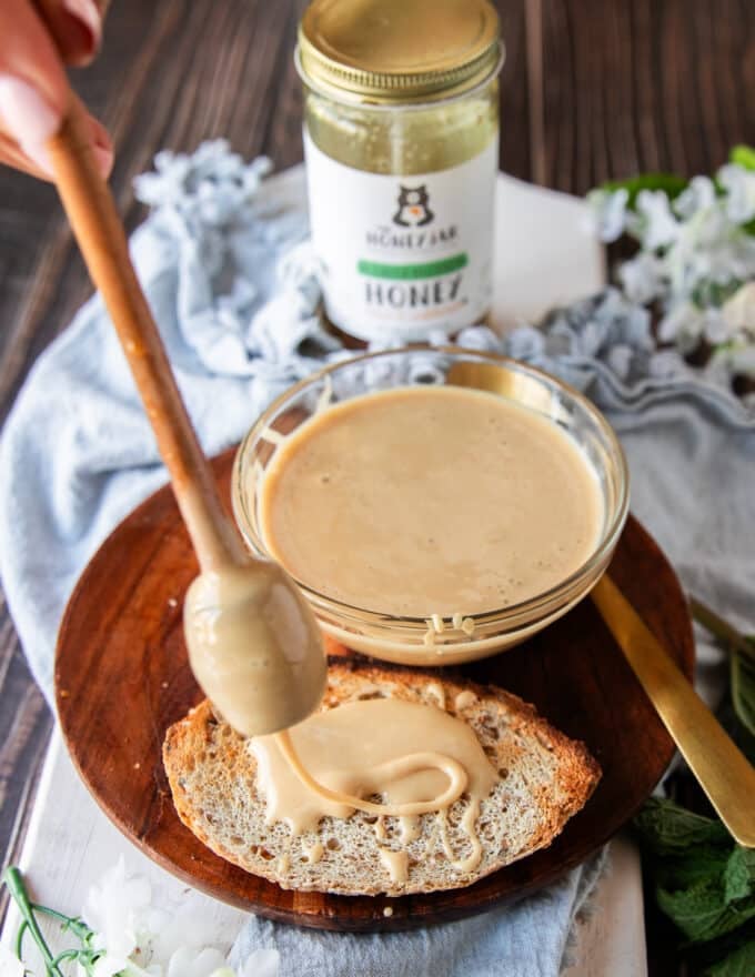 Whipped honey being spread over toast showing the texture 