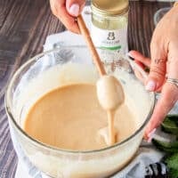 A honey stick lifting the whipped honey showing the perfect consistency