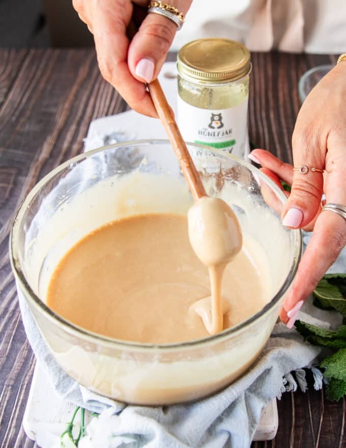 A honey stick lifting the whipped honey showing the perfect consistency
